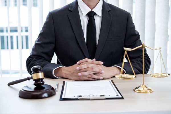Professional male lawyers work at a law office There are scales, Scales of justice, judges gavel, and litigation documents. Concepts of law and justice.